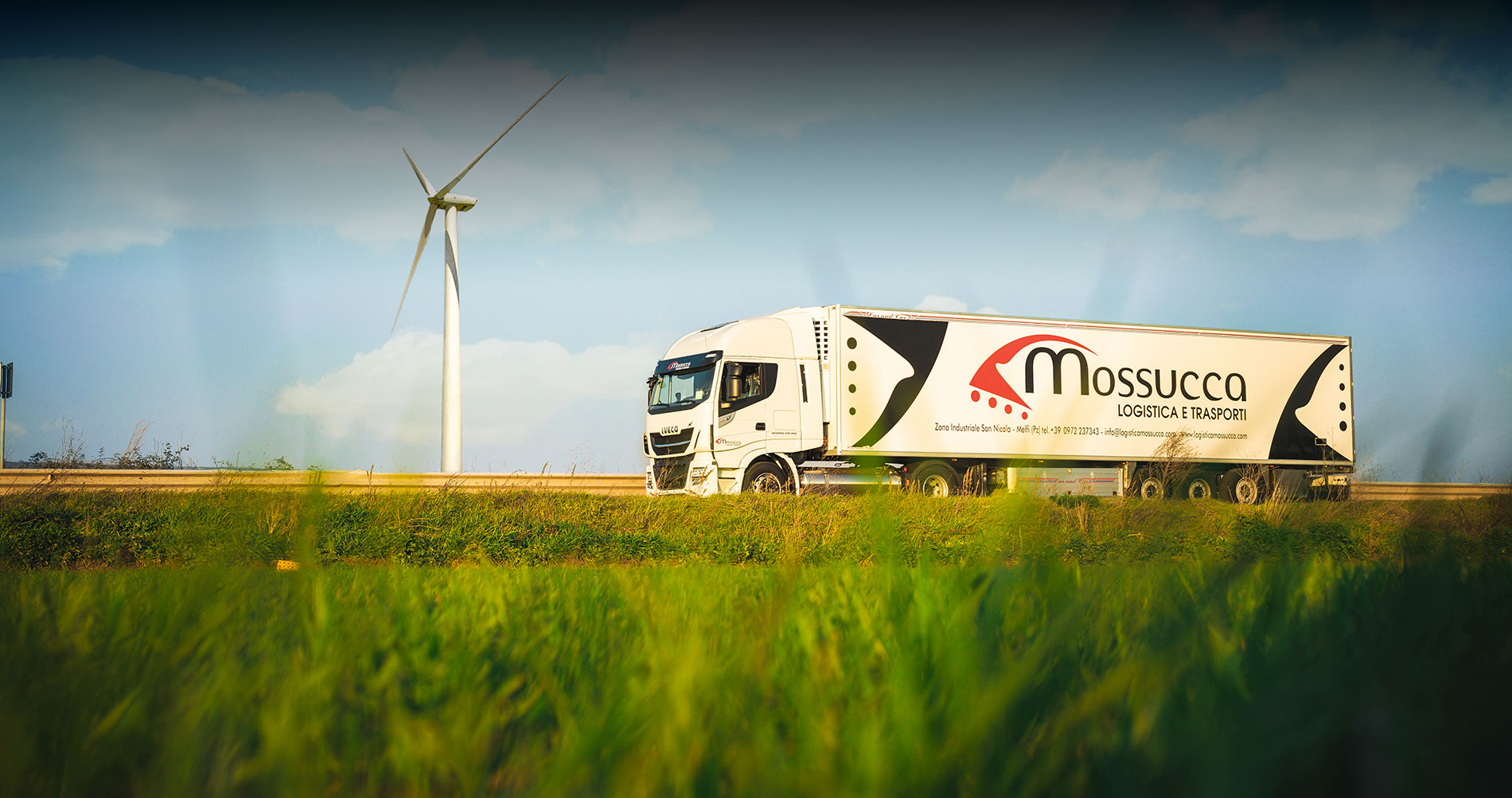 Camion Mossucca accanto a una pala eolica - logistica green