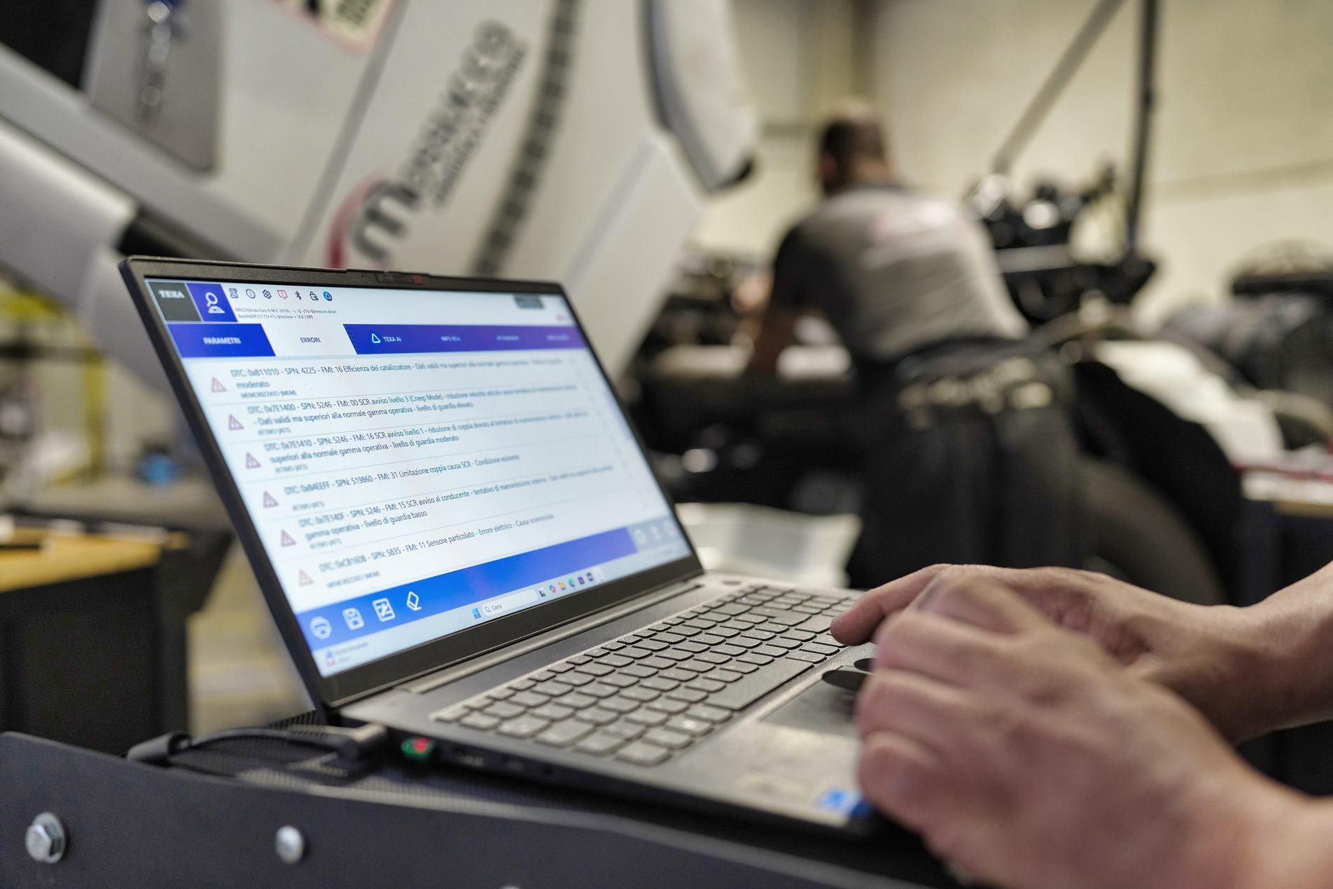 Tecnico Mossucca esegue la diagnosi computerizzata di un camion con il laptop